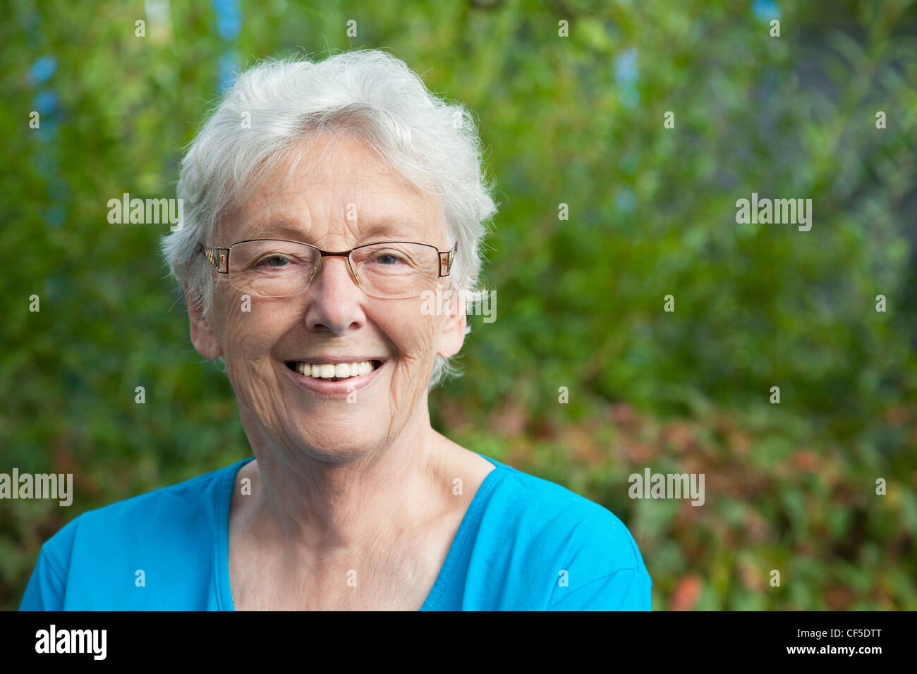 Allemagne, Bavière, Huglfing, Senior woman in garden, smiling, portrait Banque D'Images