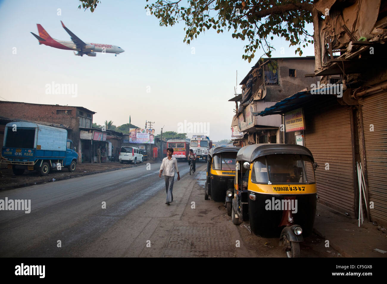 Avion à l'atterrissage à l'Aéroport International de Mumbai à côté de bidonvilles Banque D'Images