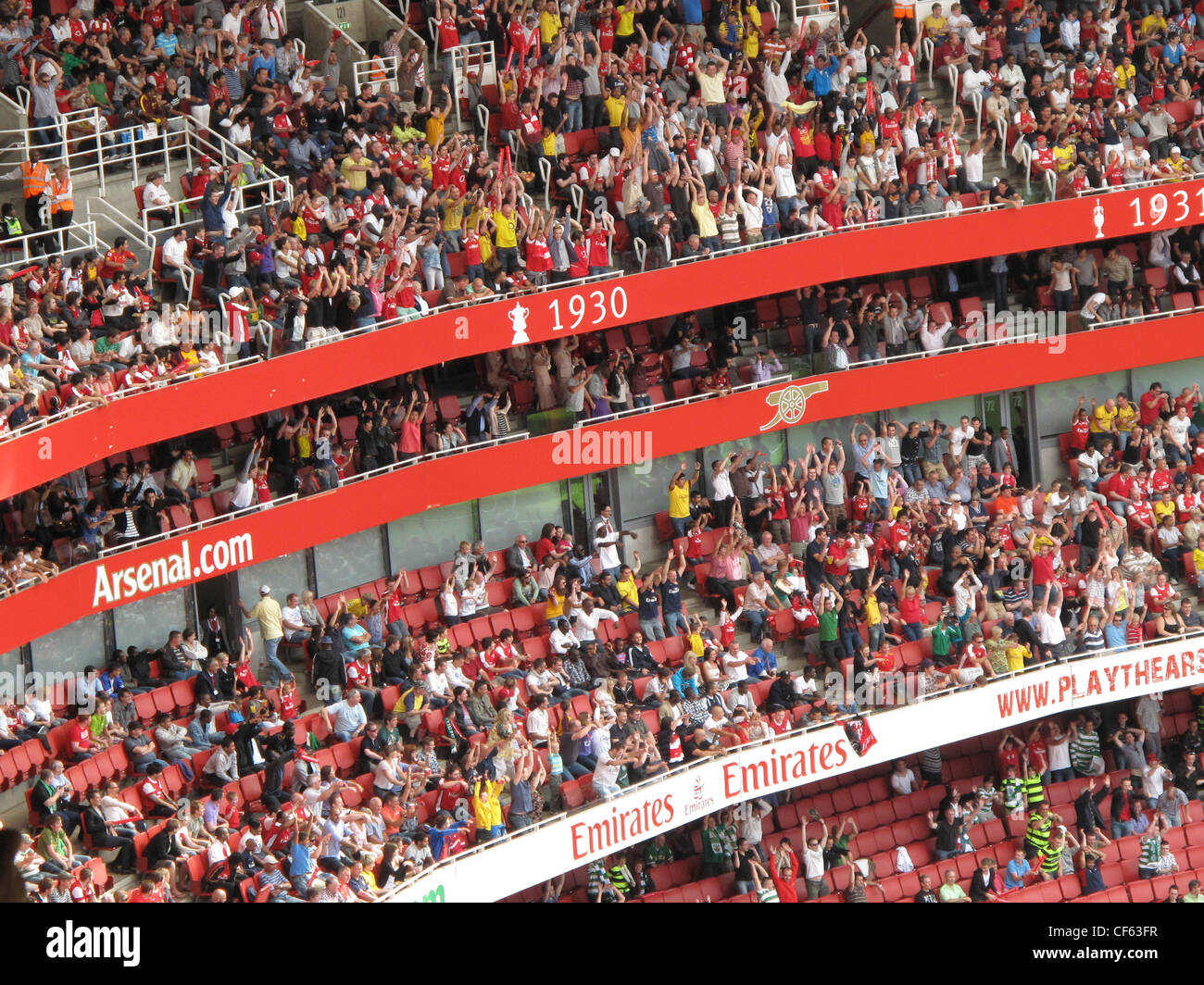 Fans participant à un 'Mexican wave' au cours de l'Emirates Cup à l'Emirates Stadium d'Arsenal. Banque D'Images