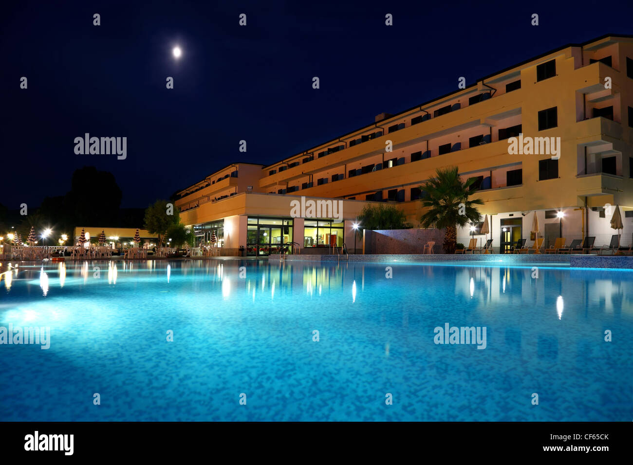 Piscine sous un ciel-ouvert en soirée près de l'hôtel qui est éclairé des lanternes Banque D'Images