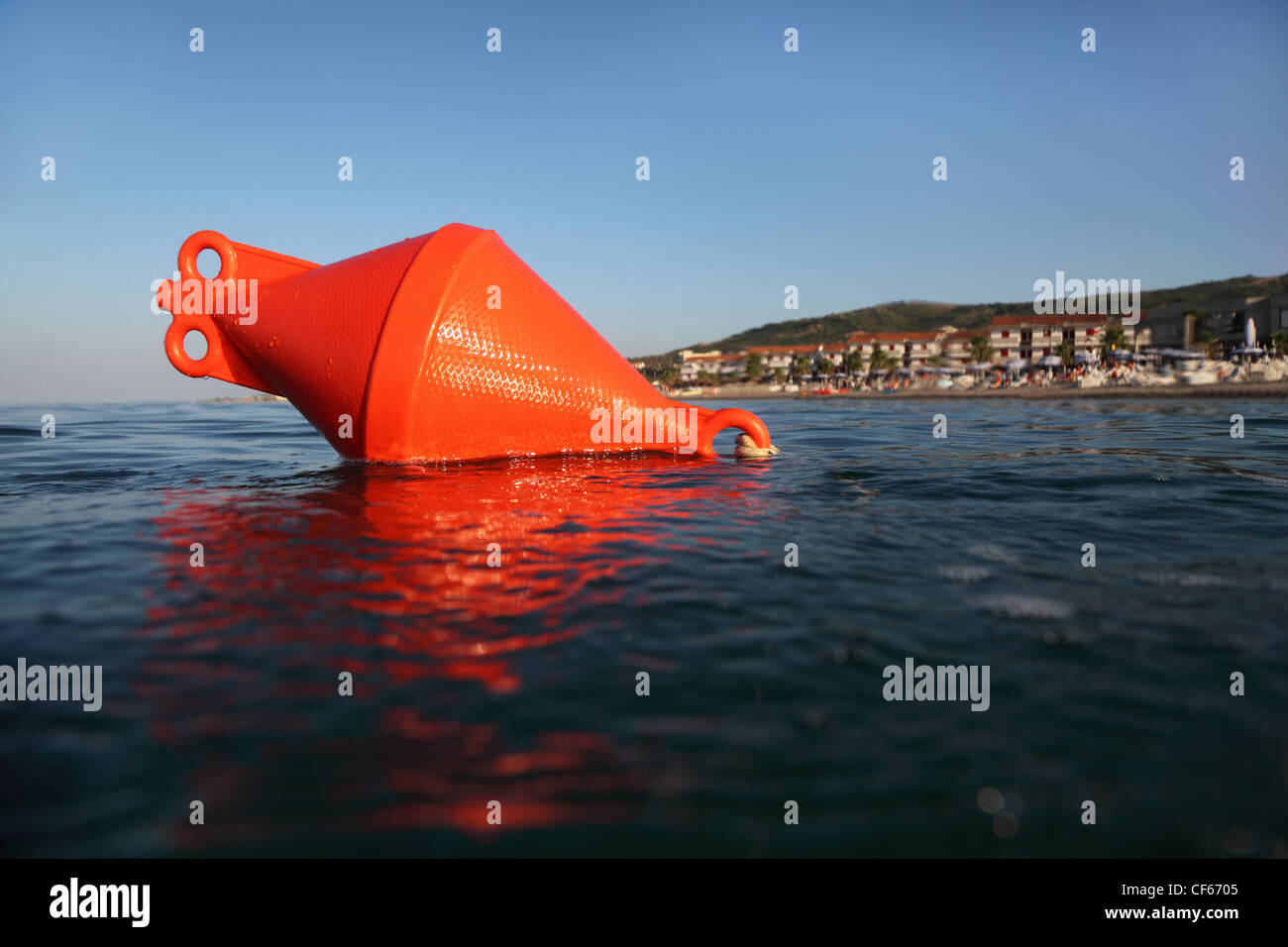 Bouée d'ancrage orange flotte sur la mer. plage pourrait être vu dans la distance Banque D'Images