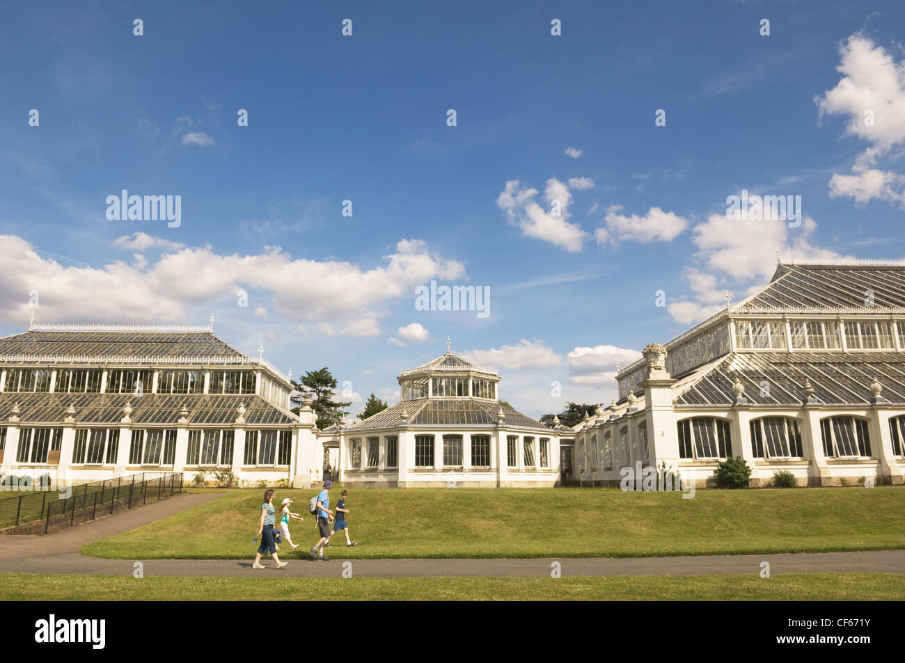 Une famille devant la maison tempérée, la plus grande serre victorienne dans le monde, à Kew Gardens. Banque D'Images