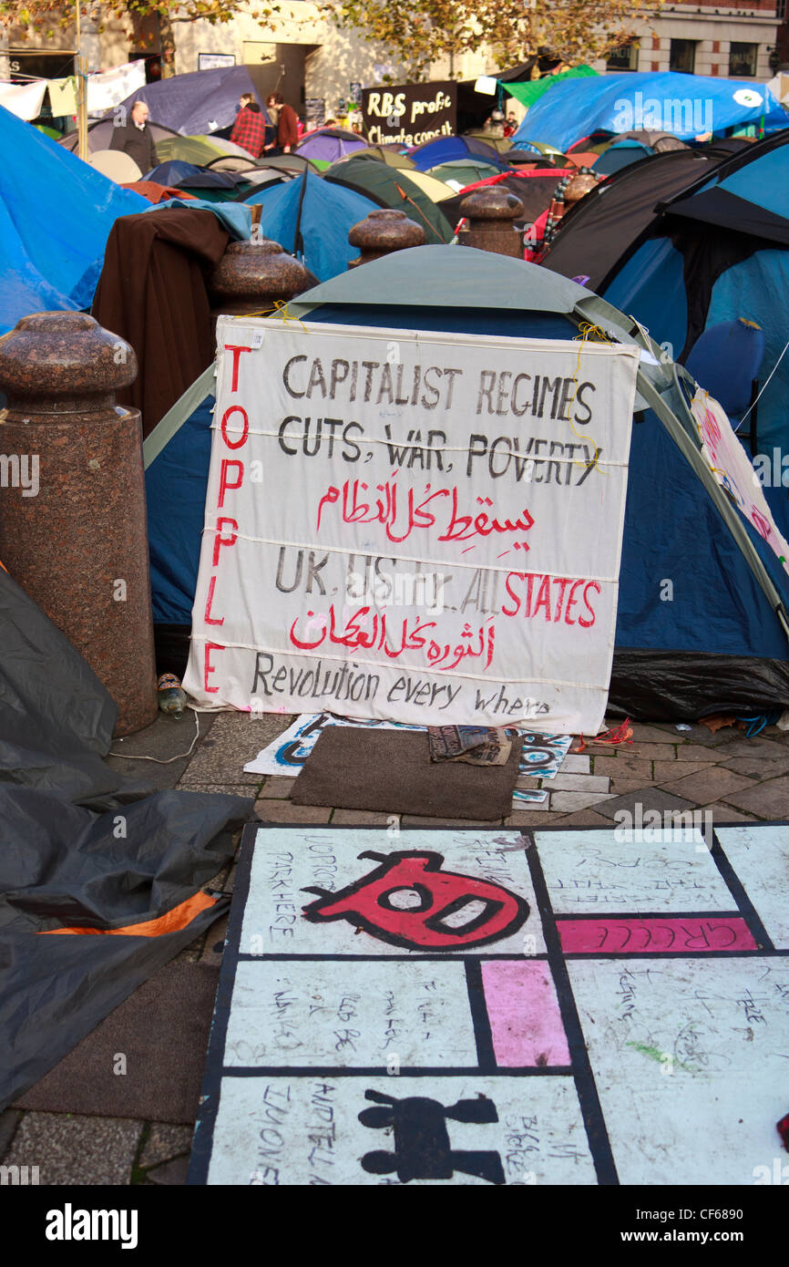 Les bannières affichées dans le capitalisme les tentes de camping par Occupy London Stock Exchange les manifestants en face de St Paul's Cathedral. Banque D'Images