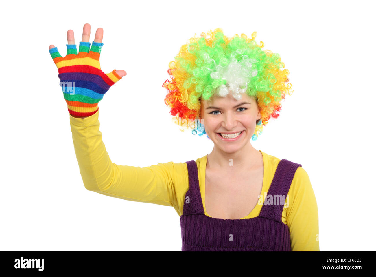 Funny Girl en perruque bouclée de couleur montre la main dans le gant multicolore Banque D'Images