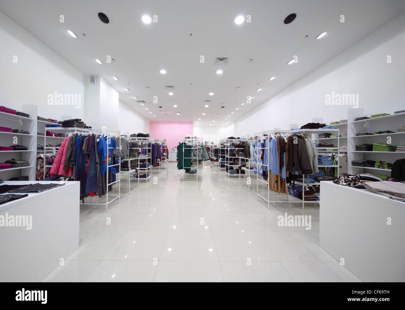 À l'intérieur de la grande boutique, white hall avec des vêtements sur les étagères et les vêtements suspendus Banque D'Images