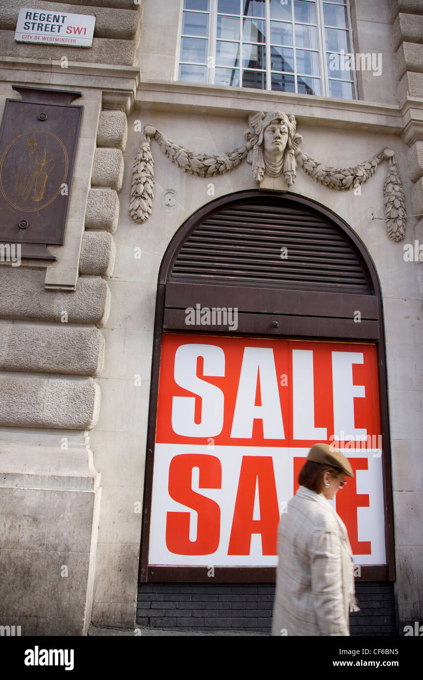 Une femme marche passé une grande vente signe pour le magasin de Lillywhite sur Regent Street à Londres. Banque D'Images