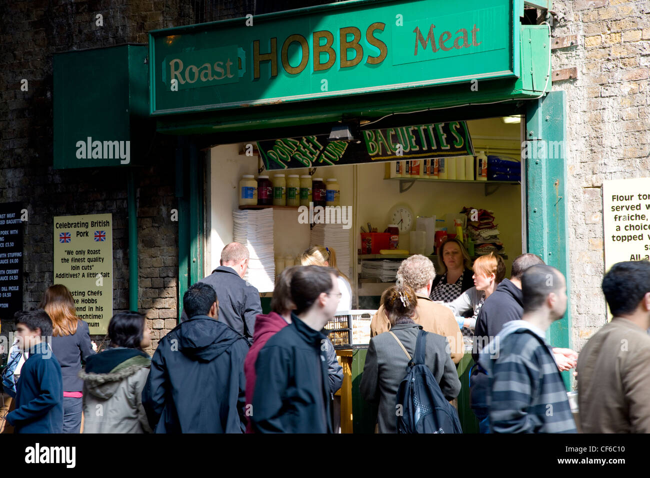 Une longue scène avec un sandwich shop vendant le traditionnel rôti de viande au Borough Market. Banque D'Images