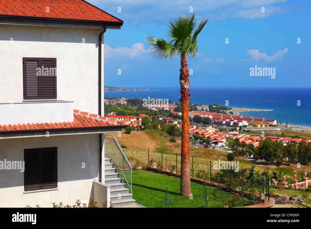 Big White maison à deux étages avec toit brun, des palmiers et des escaliers sur la côte au city Banque D'Images