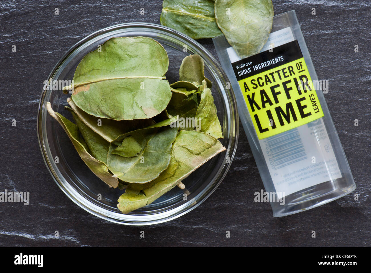 Feuilles de lime, de la ligne, les ingrédients cuisiniers Waitrose Établi sur une surface de travail de l'Ardoise Banque D'Images