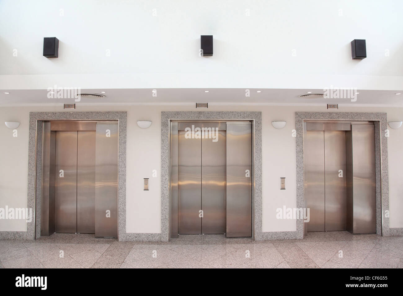 Trois ascenseurs avec chromeplated portes dans un bâtiment de bureaux hall Banque D'Images