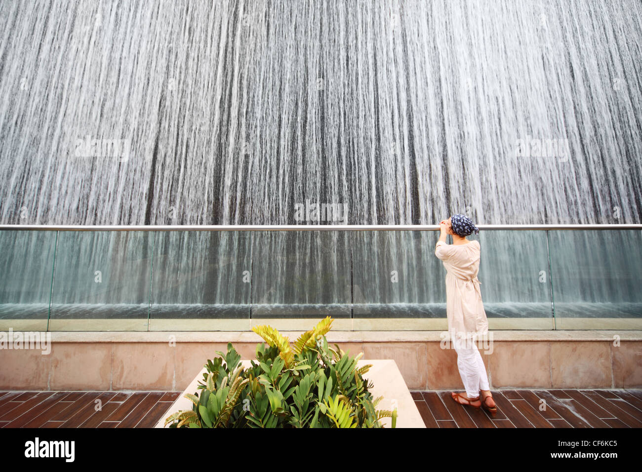Jeune beauté femme en chemise blanche, debout près de grande fontaine, un corps entier Banque D'Images