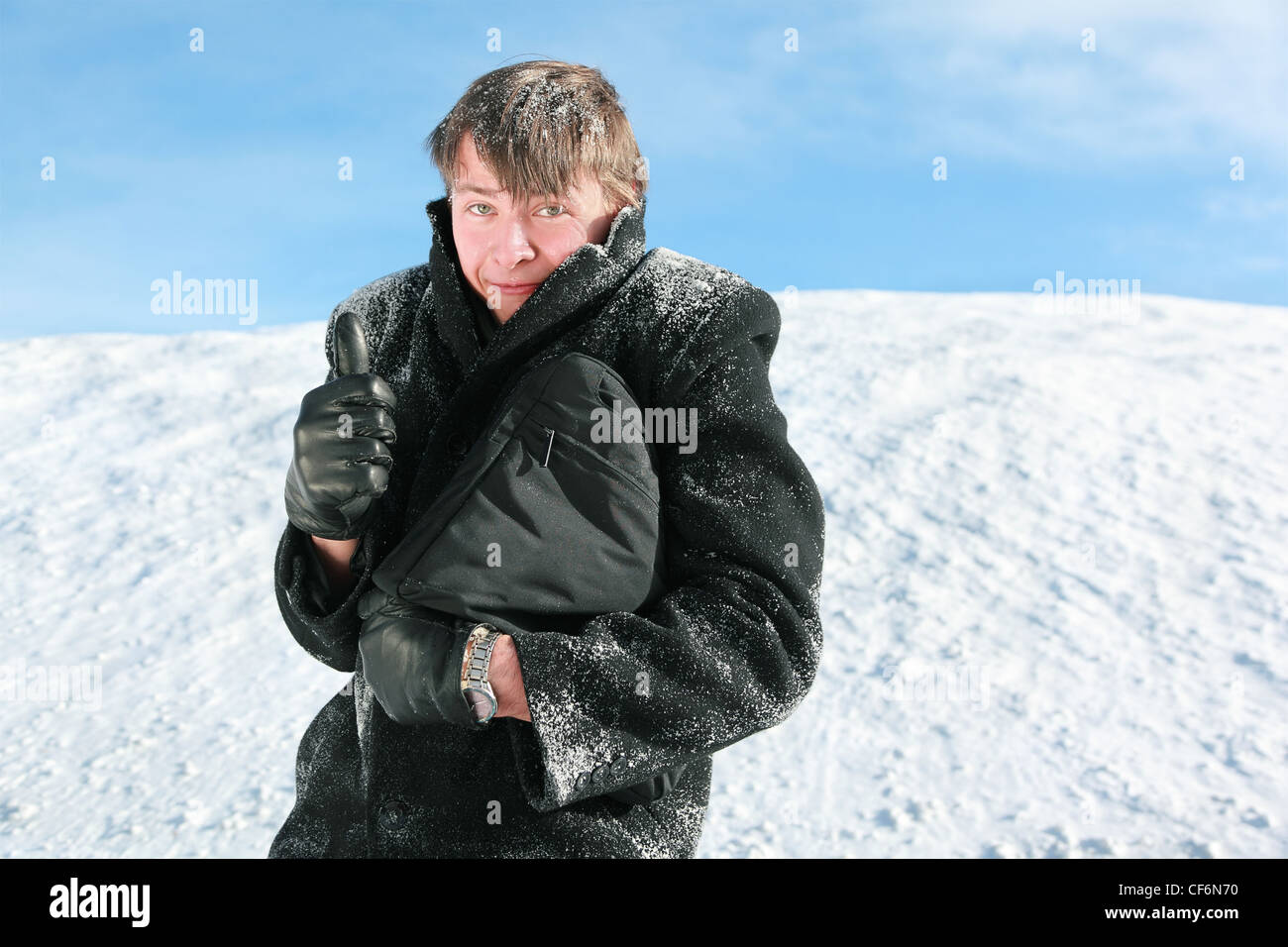 D'autres se tient en hiver sur la neige est titulaire serviette et geste montre les doigts Banque D'Images