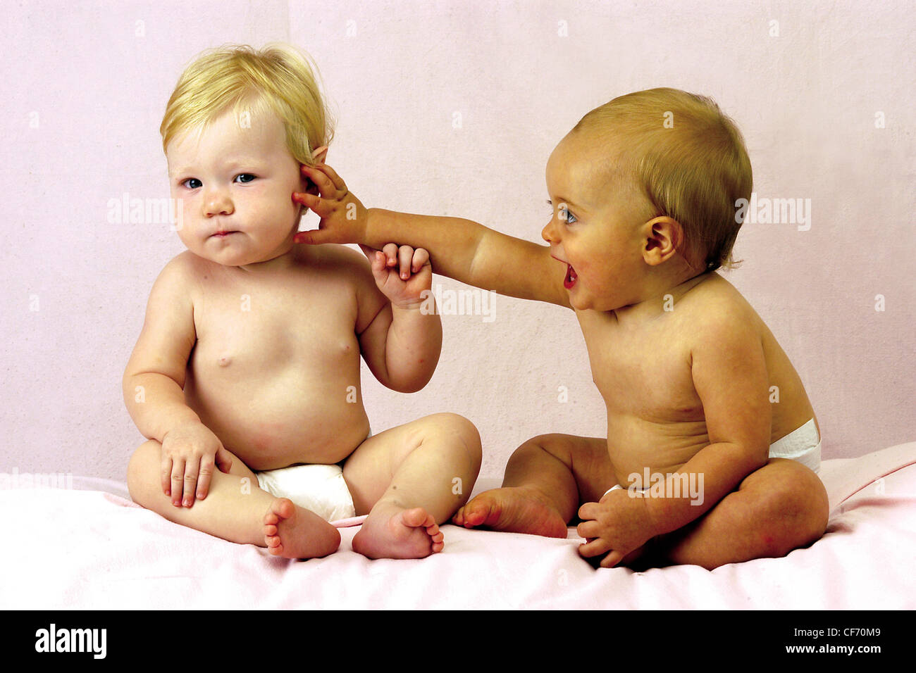 Deux Bebes Portant Des Couches Un Bebe De Toucher D Autres Sur Le Visage Photo Stock Alamy