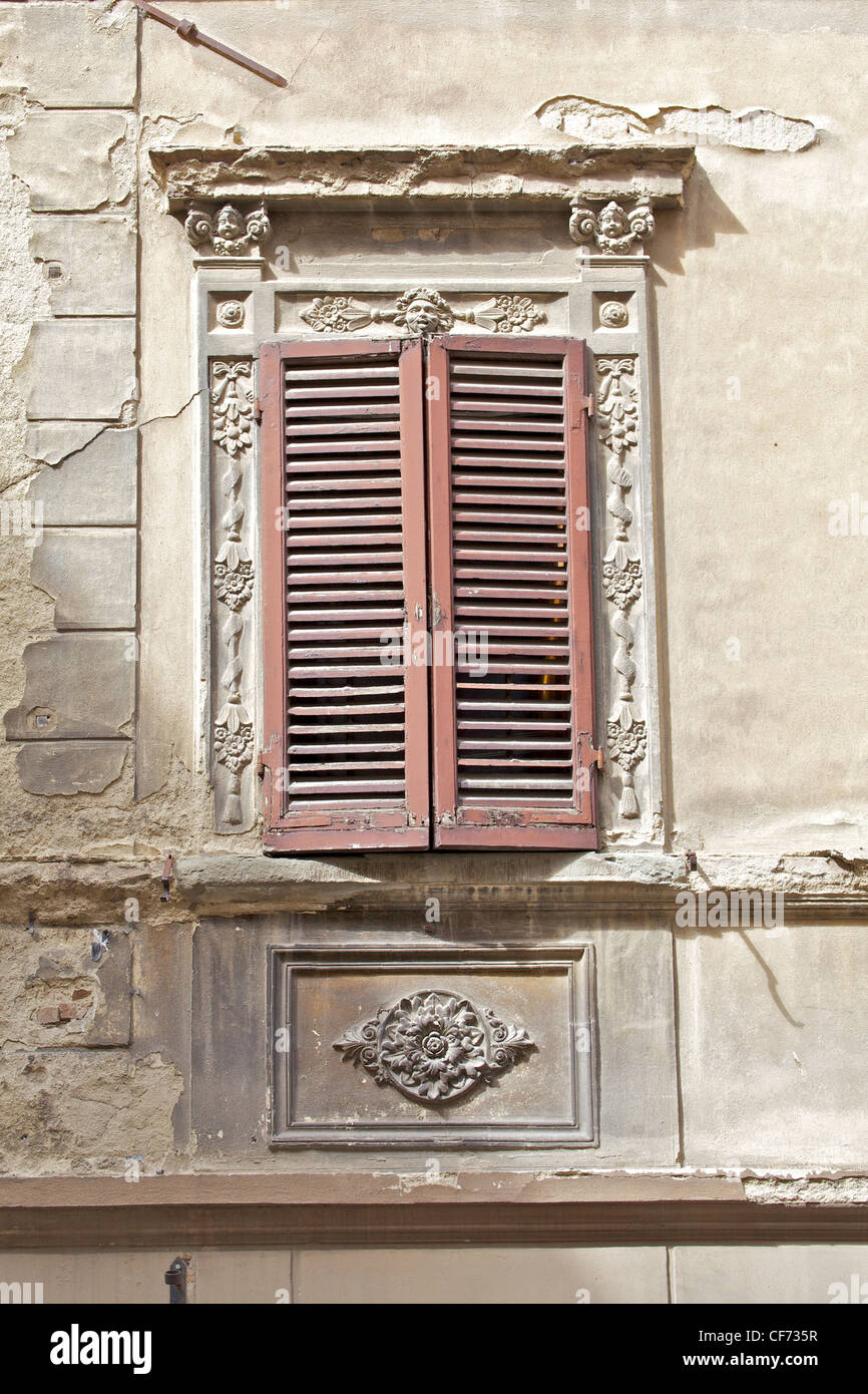 Volets en bois brun sur un mur de plâtre patiné en Toscane Banque D'Images