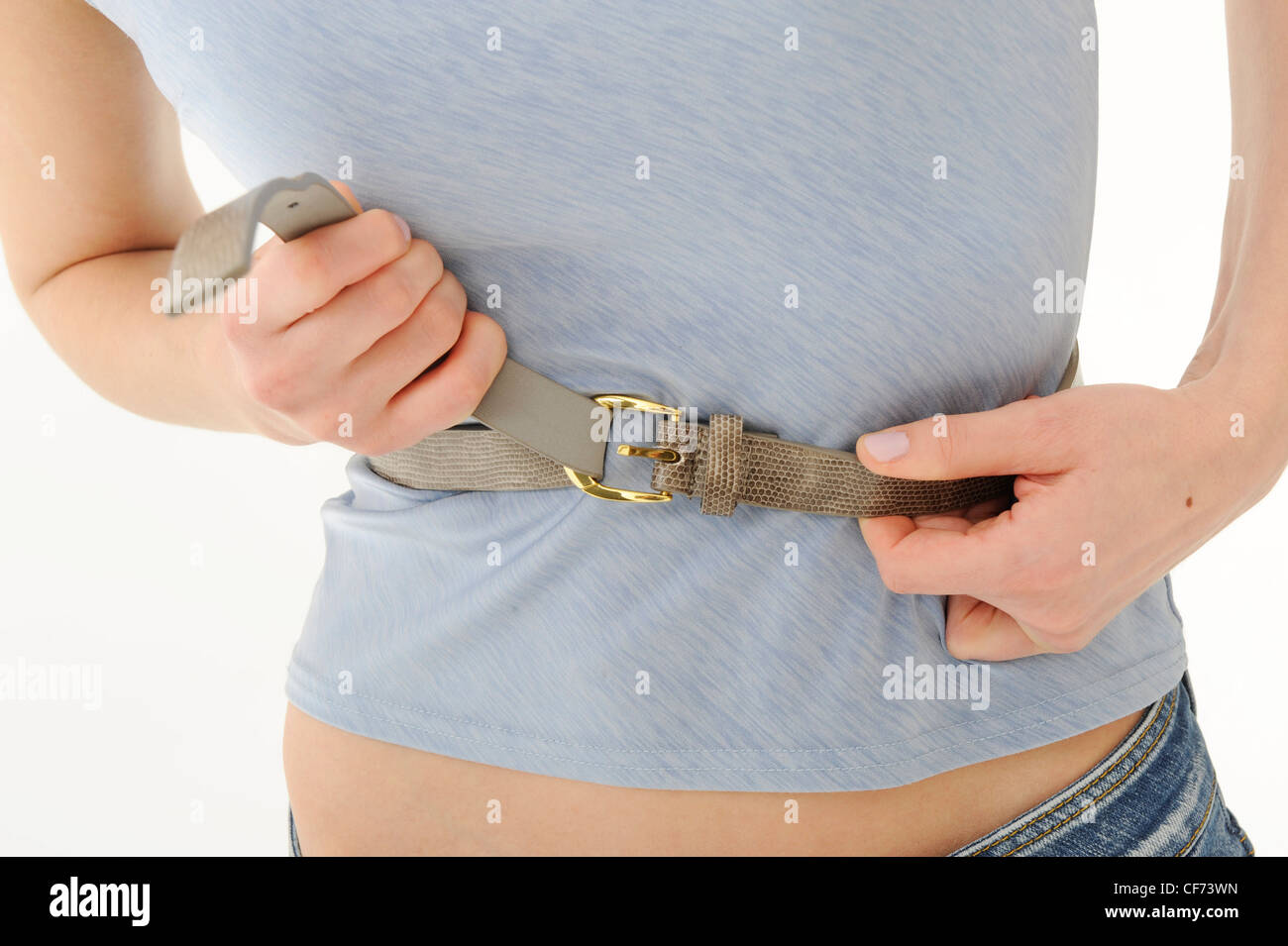 Femme portant un haut gris et un jean, l'attache ceinture brune au-dessus de taille Banque D'Images