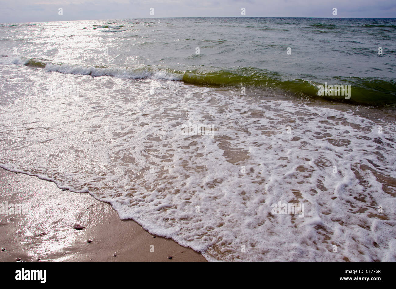 Les vagues de la Mer sable et soleil terre battre la réflexion sur l'eau. Banque D'Images