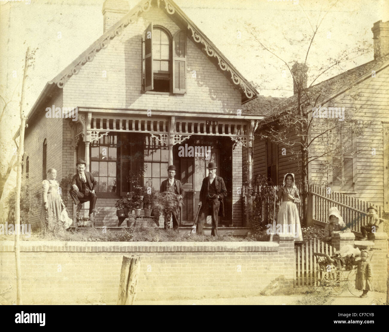 Assis en face de la famille d'accueil en bois à la fin des années 1800 ou au début des années 1900 dans l'Indiana famille pionnière homesteaders ornate archit Banque D'Images