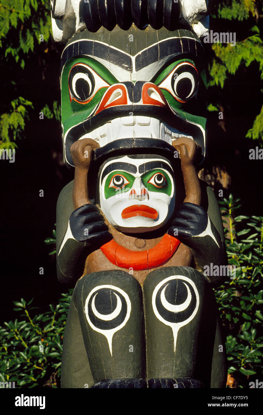 Les figures et les symboles de l'importance pour les peuples des Premières nations sont taillées dans des totems en bois coloré affiché dans Vancouver, Colombie-Britannique, Canada. Banque D'Images