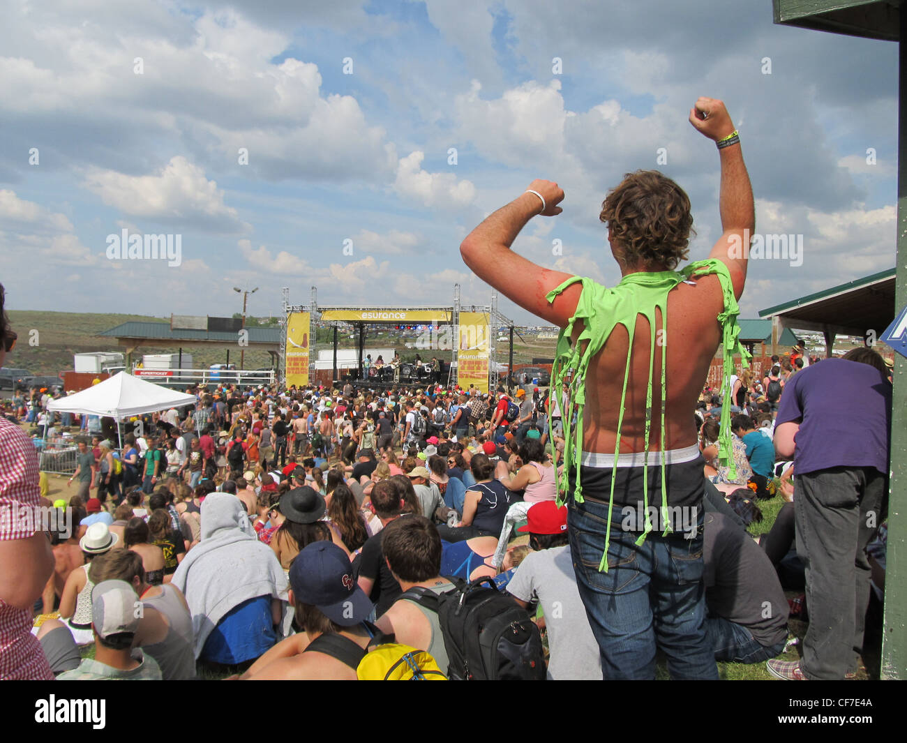 Jeune homme acclamer avec t-shirt déchiré lors d'un festival rock en plein air, Washington, USA. Banque D'Images