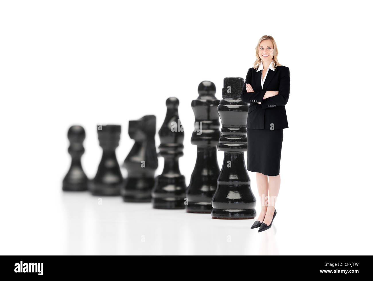 Businesswoman in front of black pièces des échecs Banque D'Images