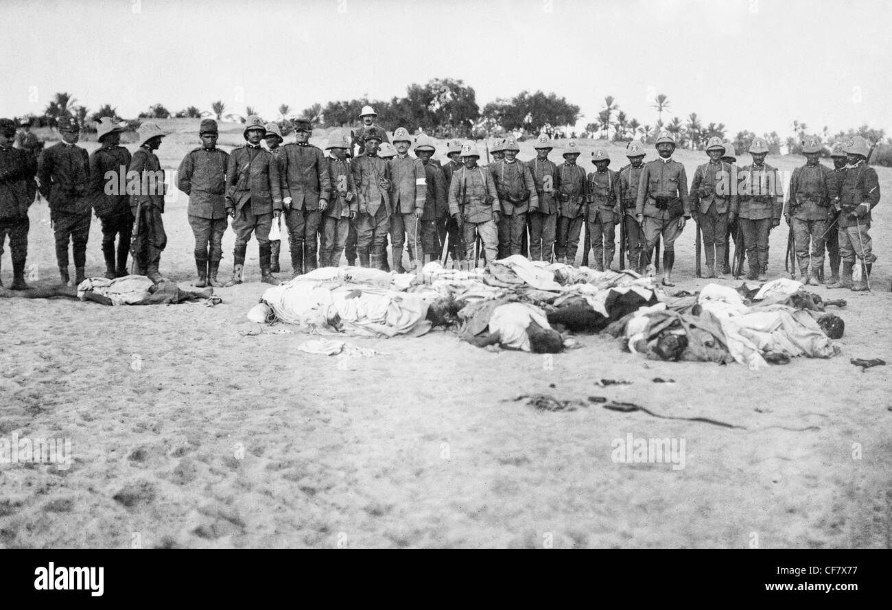 Des soldats italiens réunis autour de cadavres d'arabes pendant la guerre Italo Bain turc qui a eu lieu entre septembre 1911 et octobre 1912. Banque D'Images