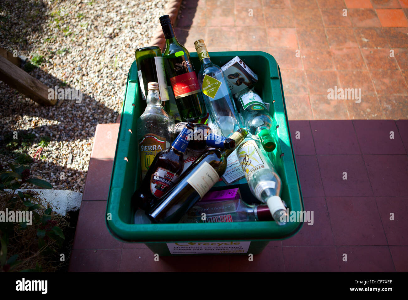 Vin vide, l'esprit et les bouteilles de bière dans le bac de recyclage vert porte. Banque D'Images