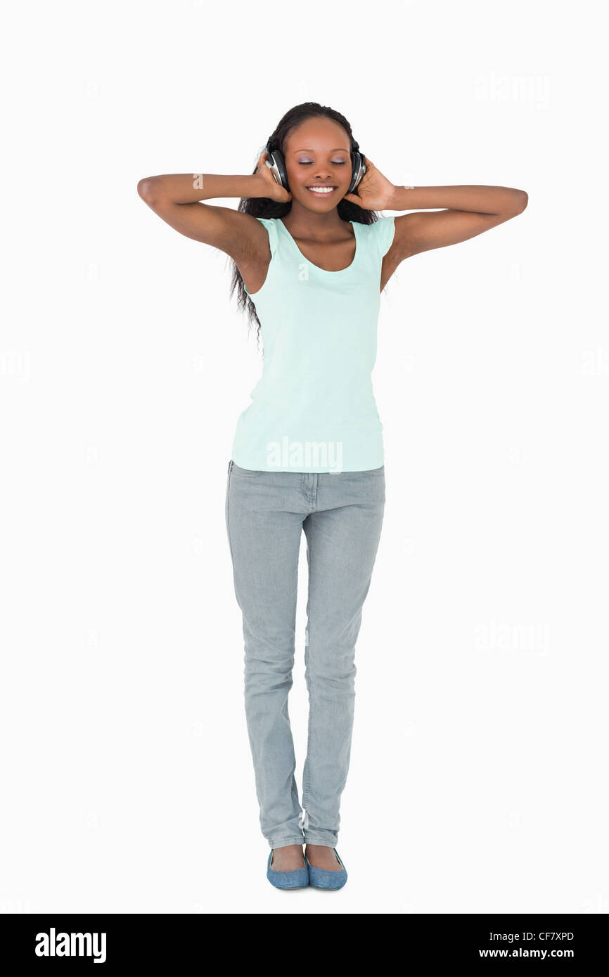 Femme d'écouter de la musique avec des écouteurs sur fond blanc Banque D'Images