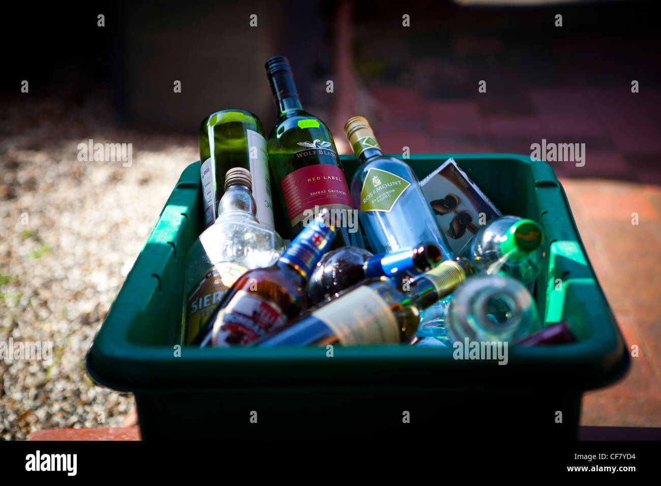 Vin vide, l'esprit et les bouteilles de bière dans le bac de recyclage vert porte. Banque D'Images