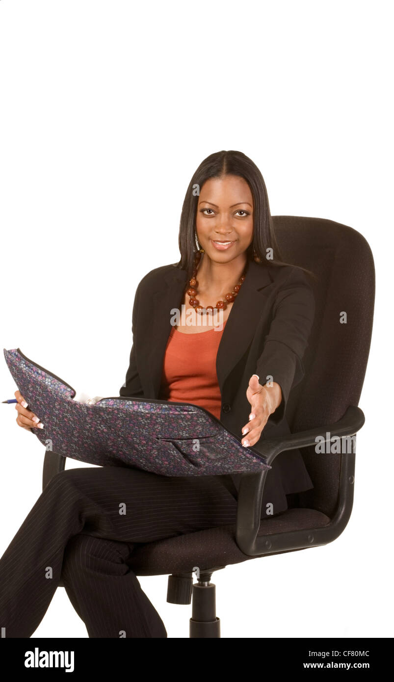 Jeune femme ethnique attrayant en tailleur est assise en chaise de bureau  avec dossier sur ses tours et s'étend vers la main viewer Photo Stock -  Alamy