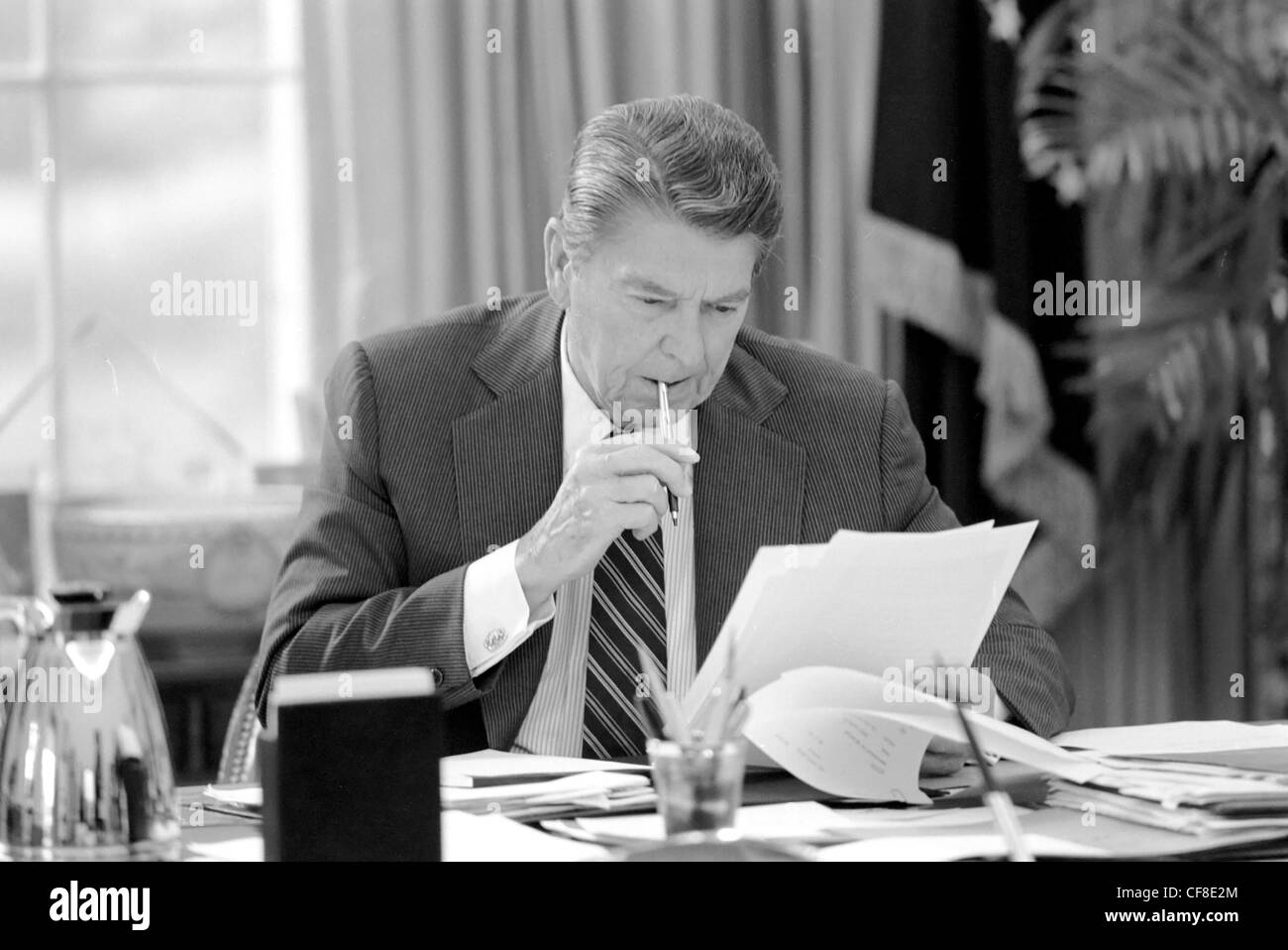 Ronald Reagan assis à son bureau dans le bureau ovale Banque D'Images