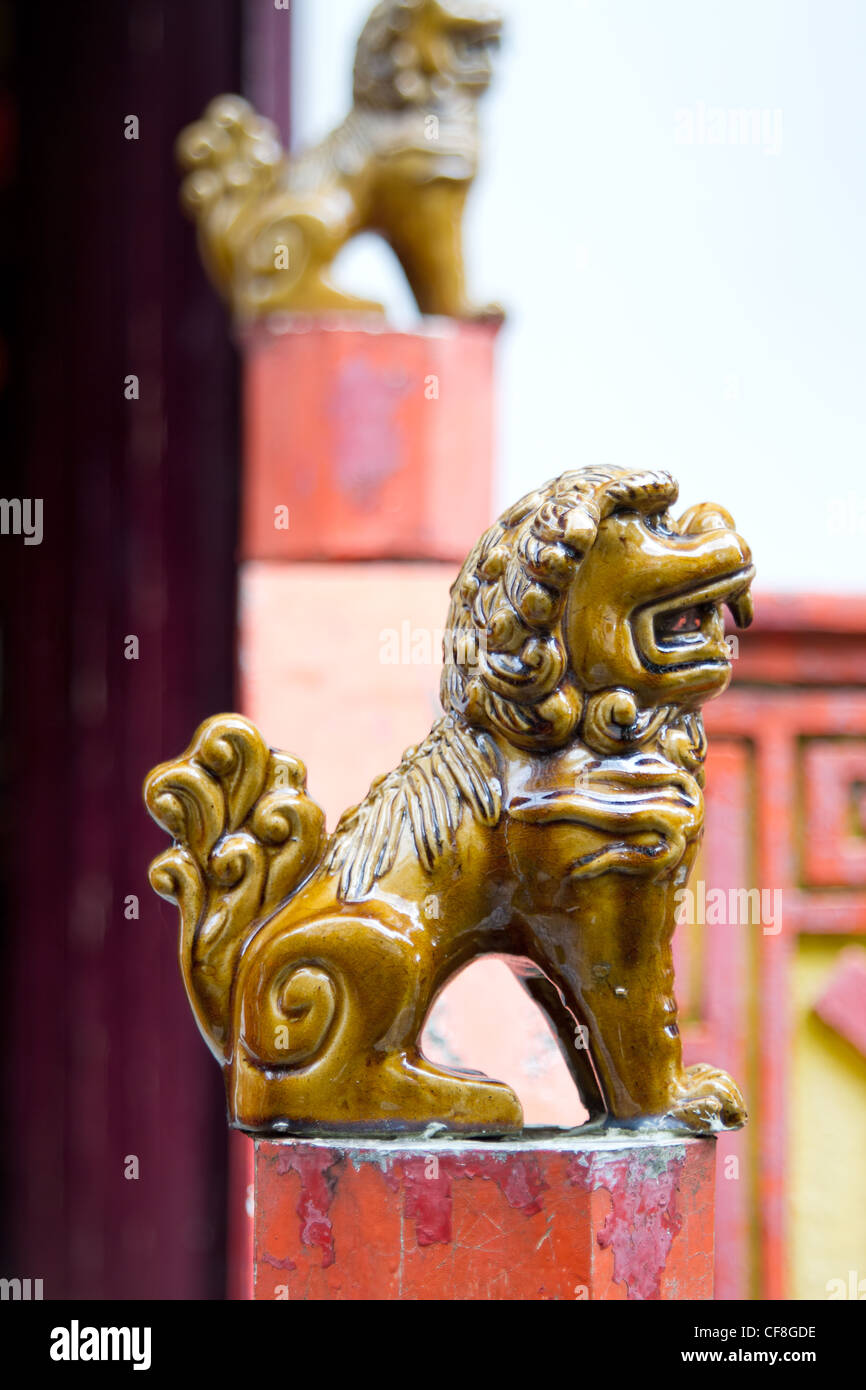 Des statues de lion Foo en céramique sur des poteaux à l'extérieur de Temple chinois Banque D'Images