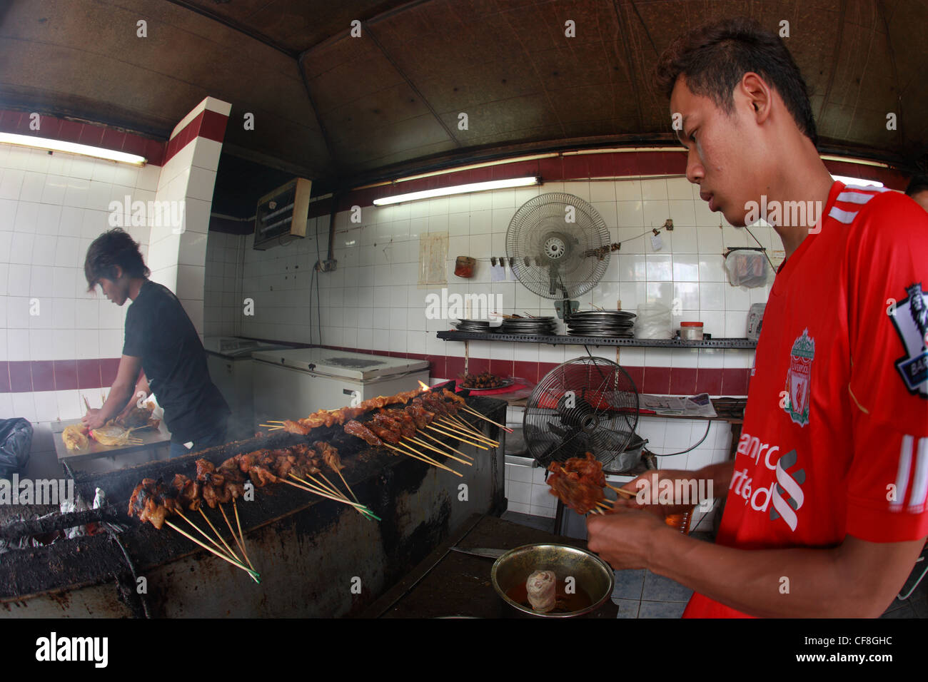 Les deux malais la préparation d'un plat local de Satay. Banque D'Images