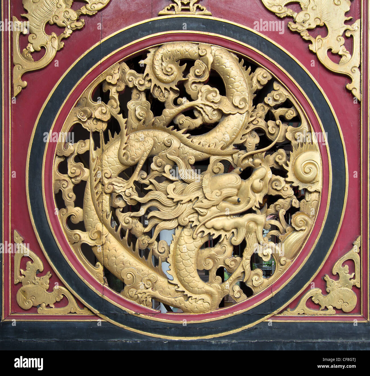 Dragon chinois de sculpture sur bois sur l'extérieur de porte du temple avec Motif chauve-souris Banque D'Images