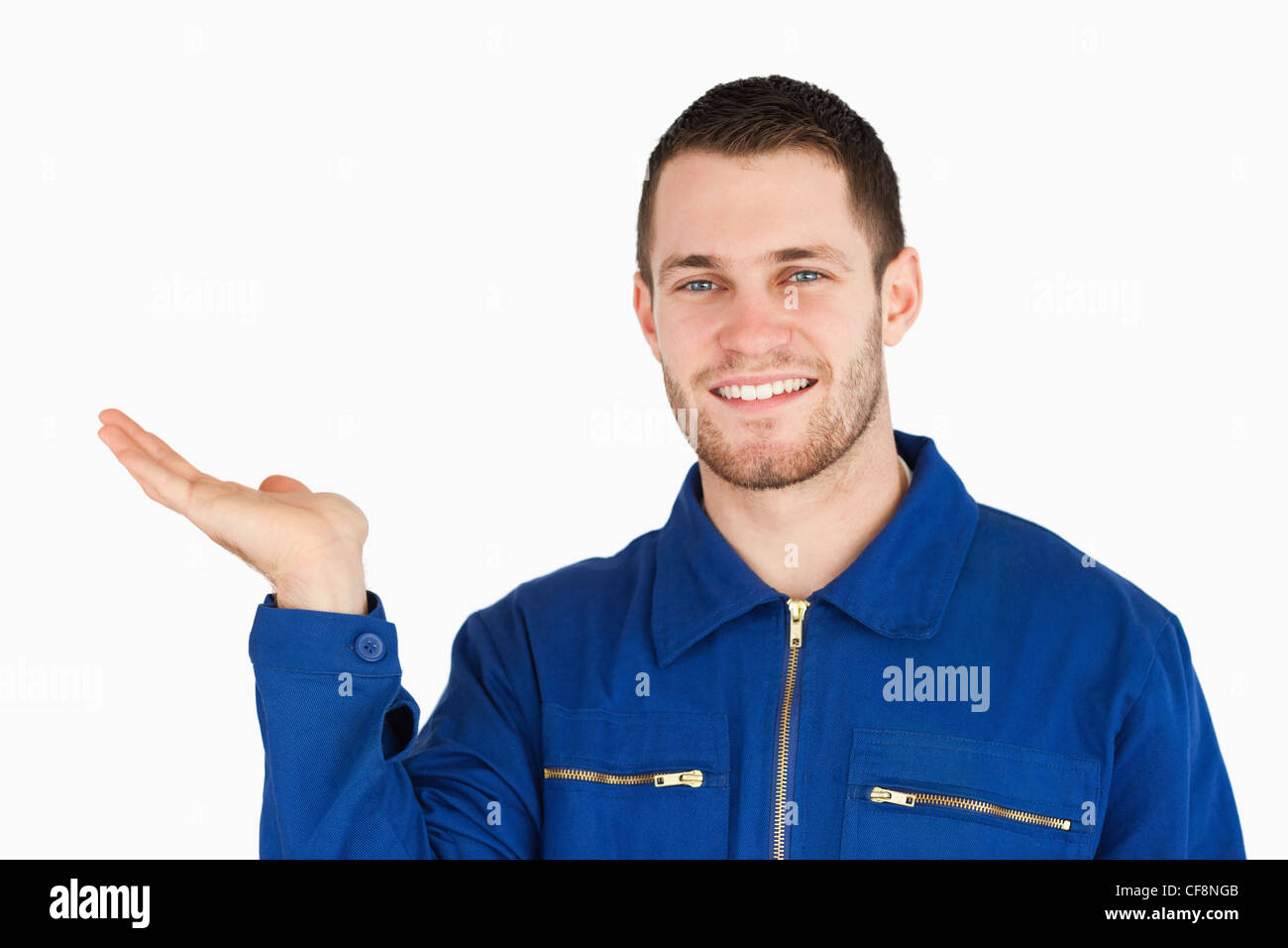 Smiling young mechanic présenter quelque chose dans sa paume Banque D'Images