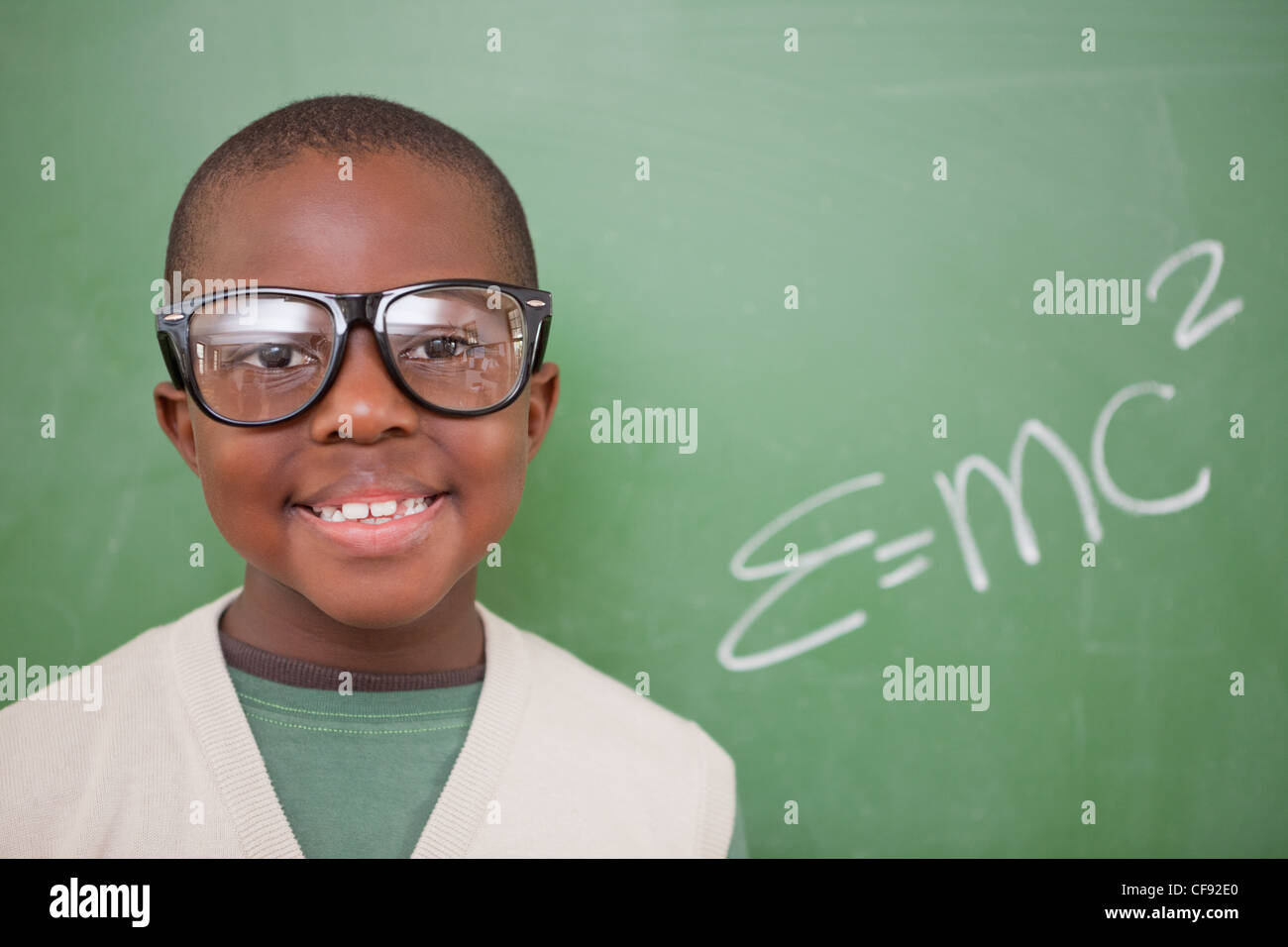 L'écolier posant avec la formule d'équivalence masse-énergie Banque D'Images