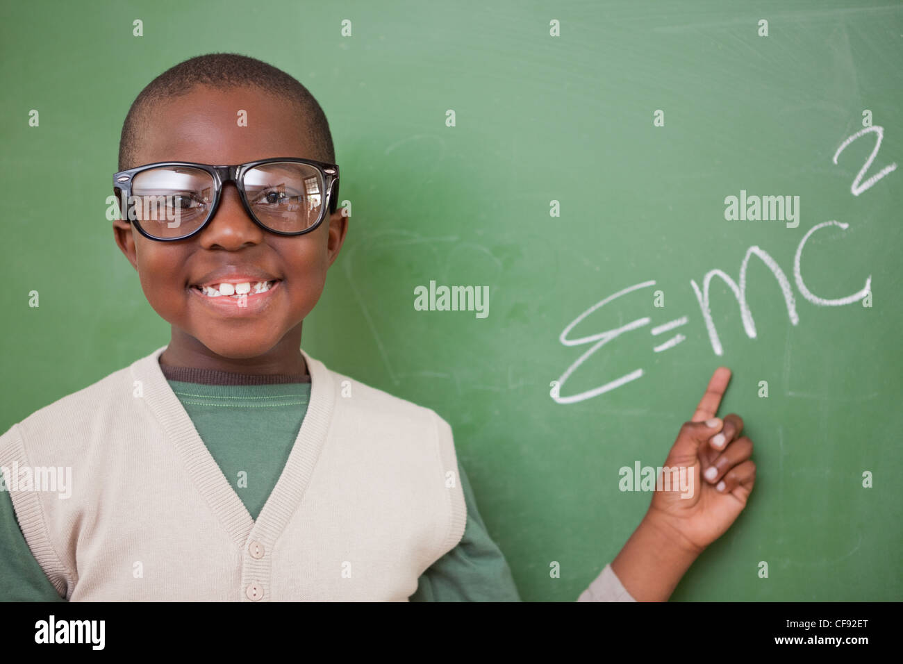 Smart schoolboy montrant le la formule d'équivalence masse-énergie Banque D'Images