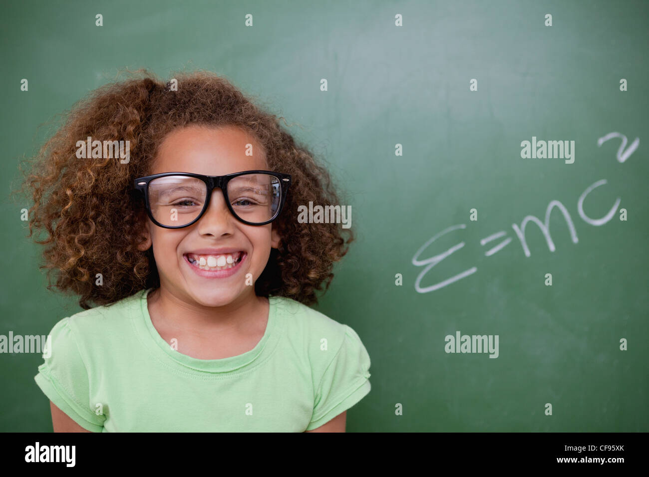 Lycéenne posant avec le la formule d'équivalence masse-énergie Banque D'Images