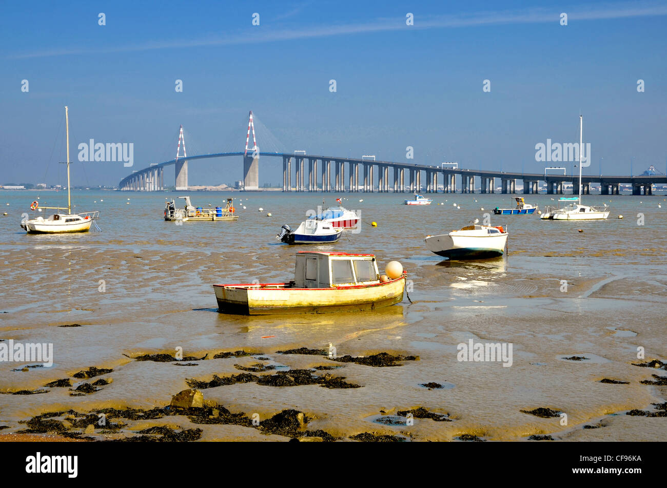 Les petits bateaux à marée basse et le grand pont de Saint Nazaire à Saint Brevin les Pins en France Banque D'Images