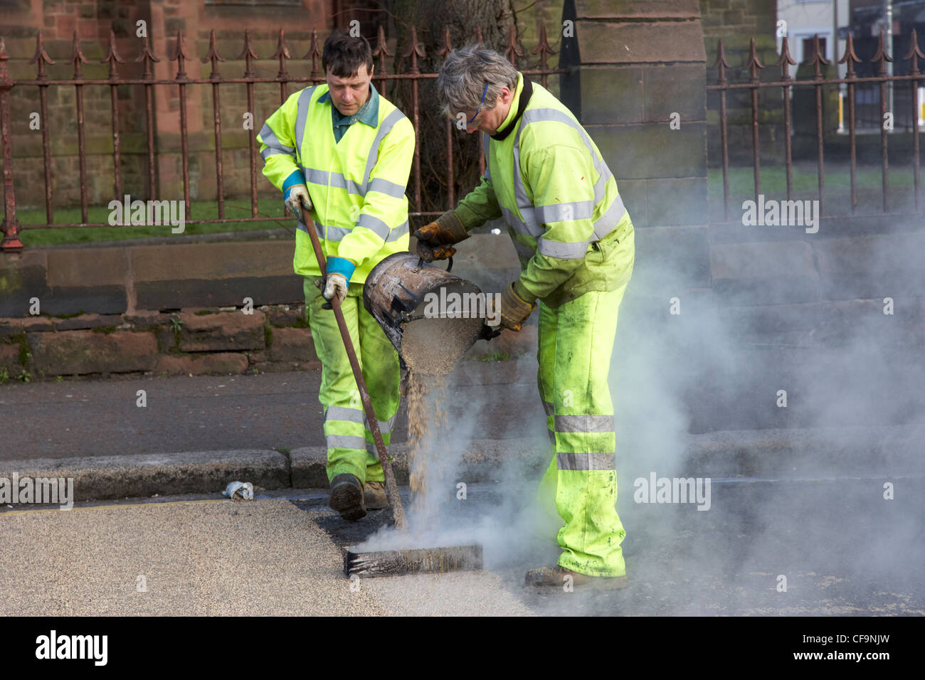 Les travailleurs de la construction routière appliquée à chaud de l'installation de revêtement routier de frottement élevé Royaume-Uni Irlande du Nord Belfast Banque D'Images