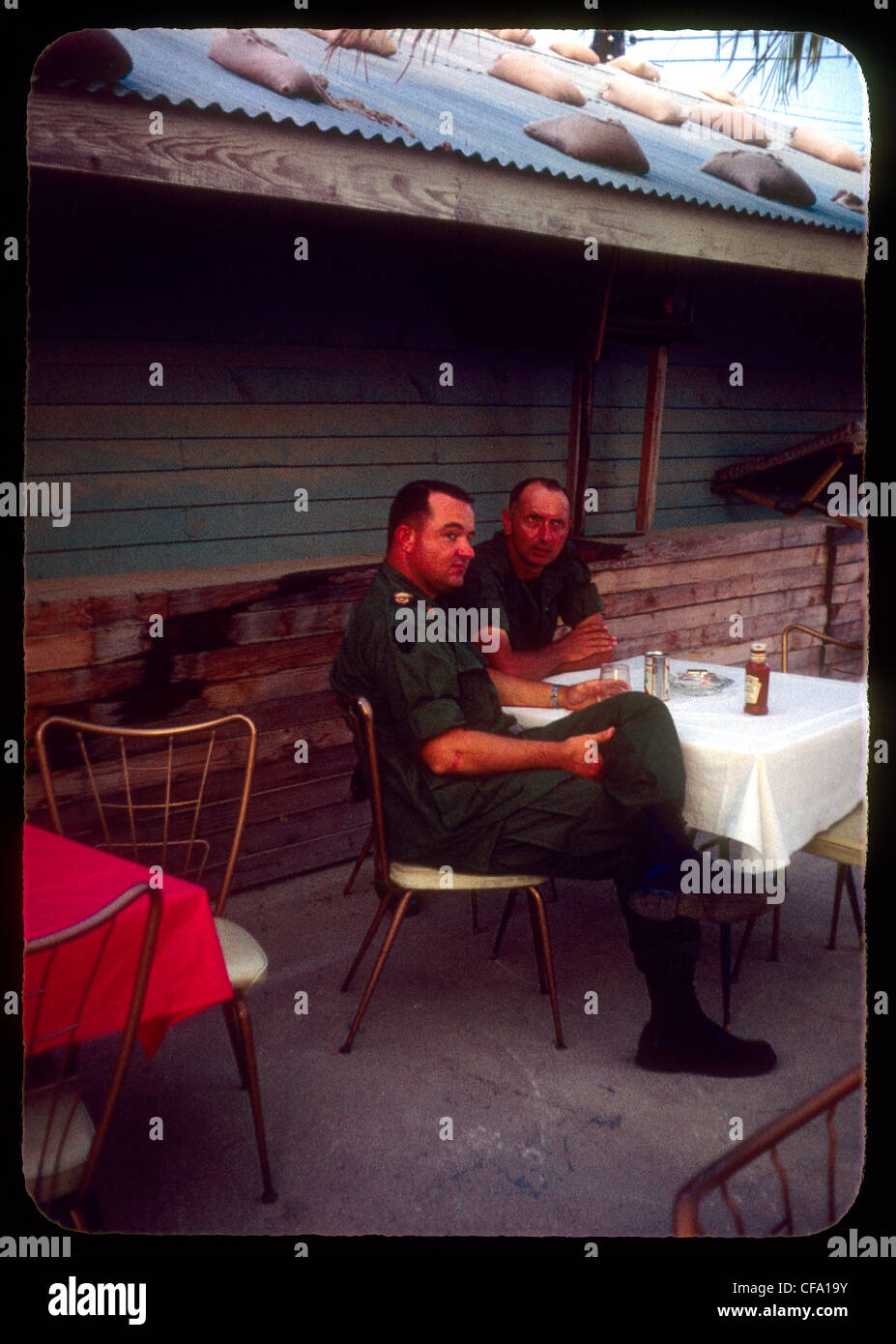 Officiers dans l'armée US se détendre dans leur mess extérieur durant la guerre du Vietnam le ketchup Heinz 1960 ration de bière Banque D'Images