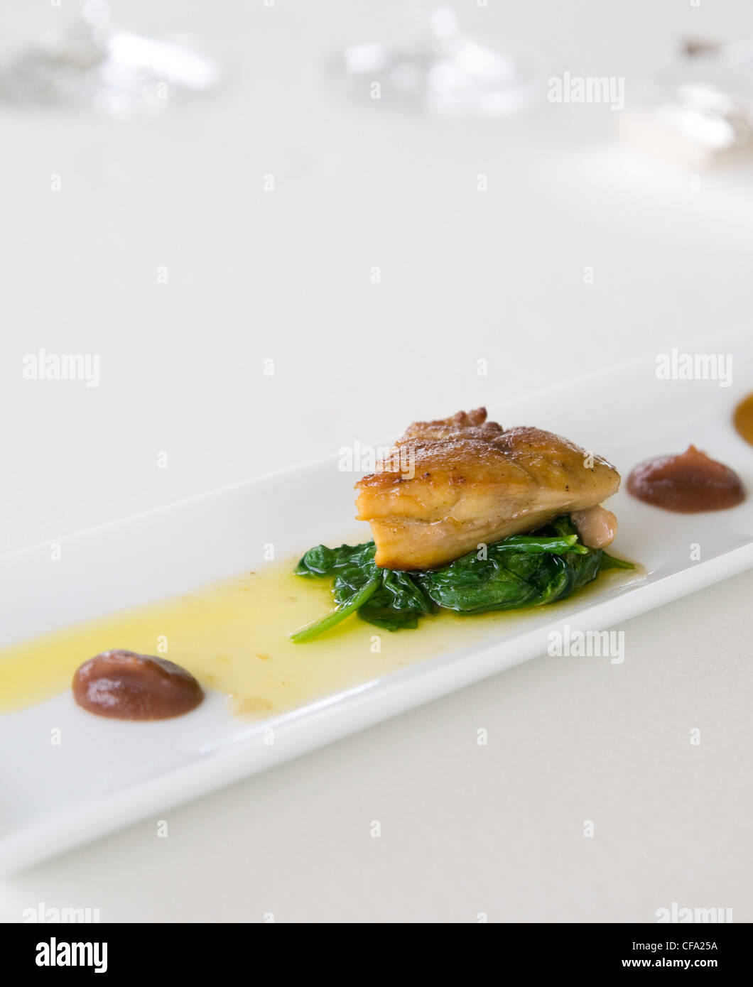 Apéritif au restaurant de luxe, foie d'oie sur les épinards. Profondeur de champ avec la nourriture dans l'accent. Banque D'Images