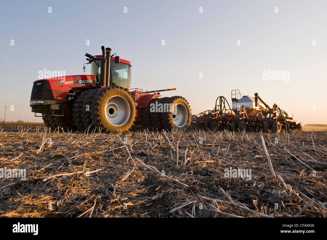 Déplacer le tracteur et l'air et jusqu'à la plantation semoir grain dans le chaume de canola, près de Dugald (Manitoba), Canada Banque D'Images