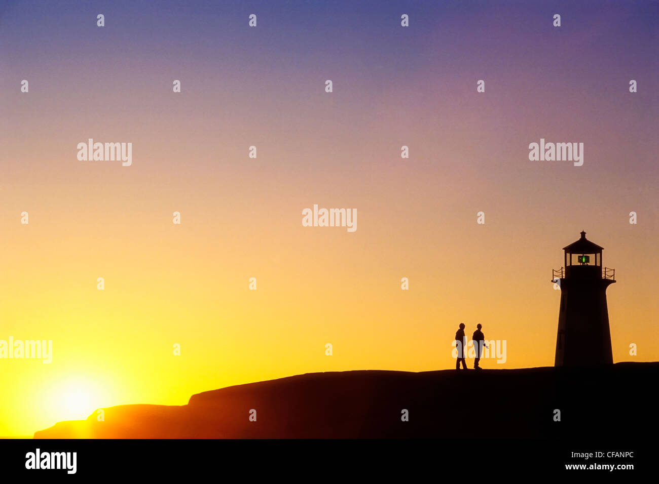 Silhouette de phare et deux personnes au coucher du soleil, Peggy's Cove, Nova Scotia, Canada Banque D'Images