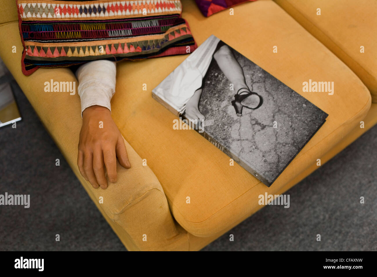 Bras artificiel sur le canapé à côté de livre de photographies des photographies du crime Banque D'Images