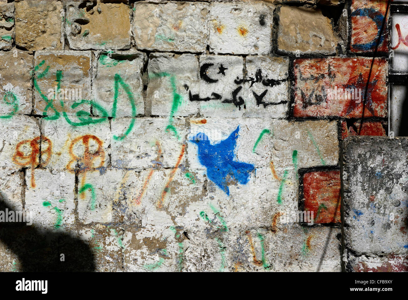 Colombe de la paix montrant des graffitis sur un mur à Jérusalem et écrit en arabe, aux côtés le croissant de lune signe de l'islam Banque D'Images