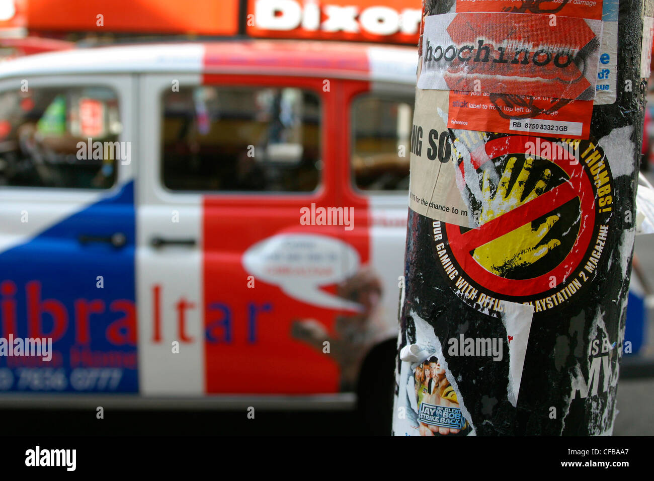 Taxi Union Jack passant couvert de graffitis lamp post Banque D'Images