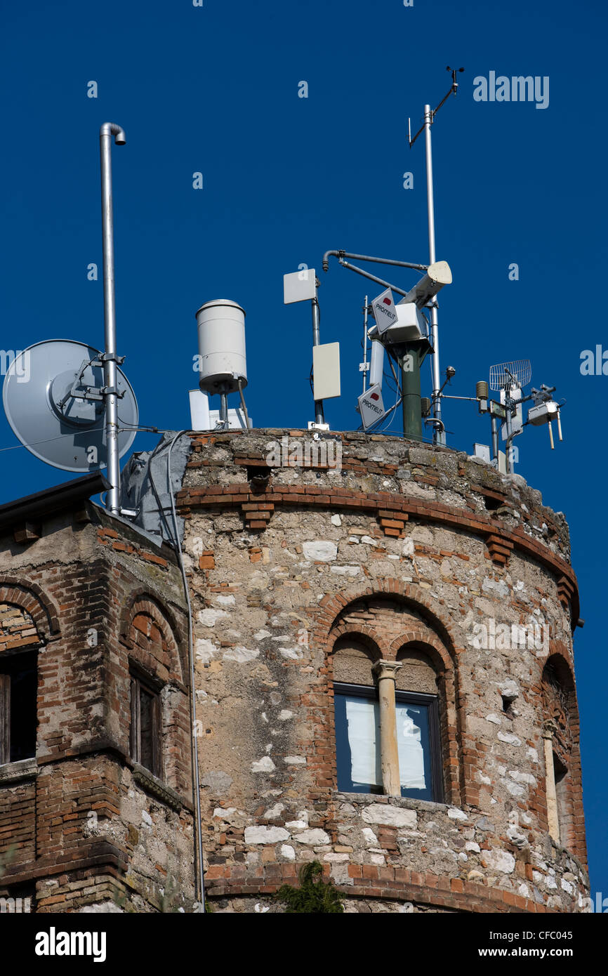 Gamme de mâts et d'antennes de téléphonie mobile sur le dessus d'une ancienne tour ronde en Italie Banque D'Images