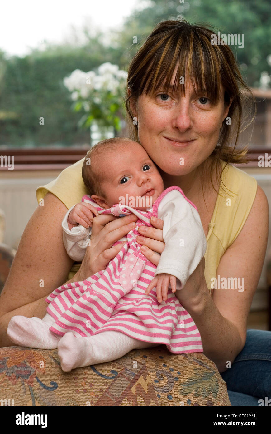 Un Nouveau Ne Bebe Femme Habillee D Une Robe Rose Et Blanc Etant Detenu Par Une Femme Photo Stock Alamy