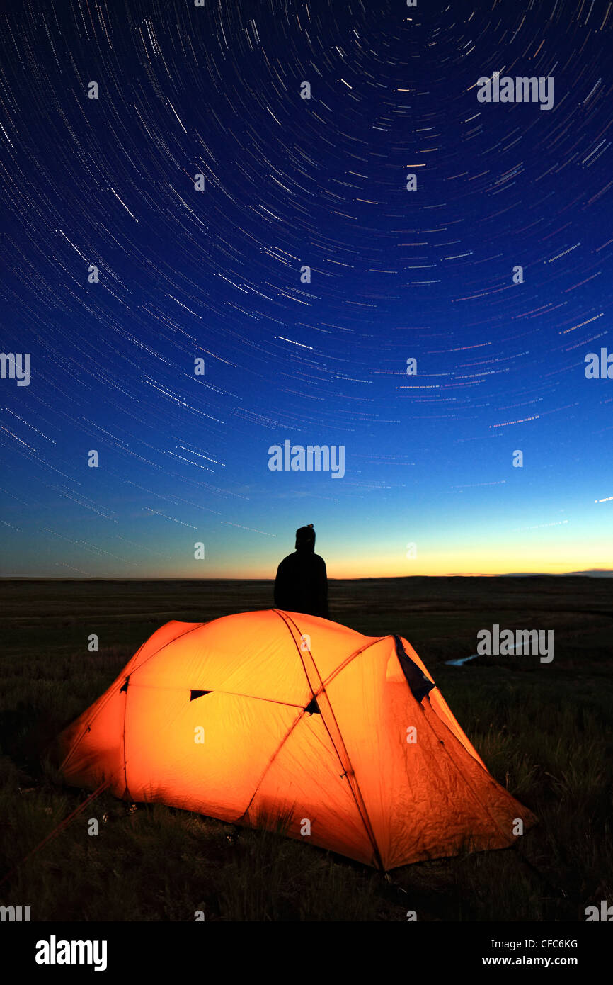 Stargazing personne tente illuminée nuit donnant sur Banque D'Images
