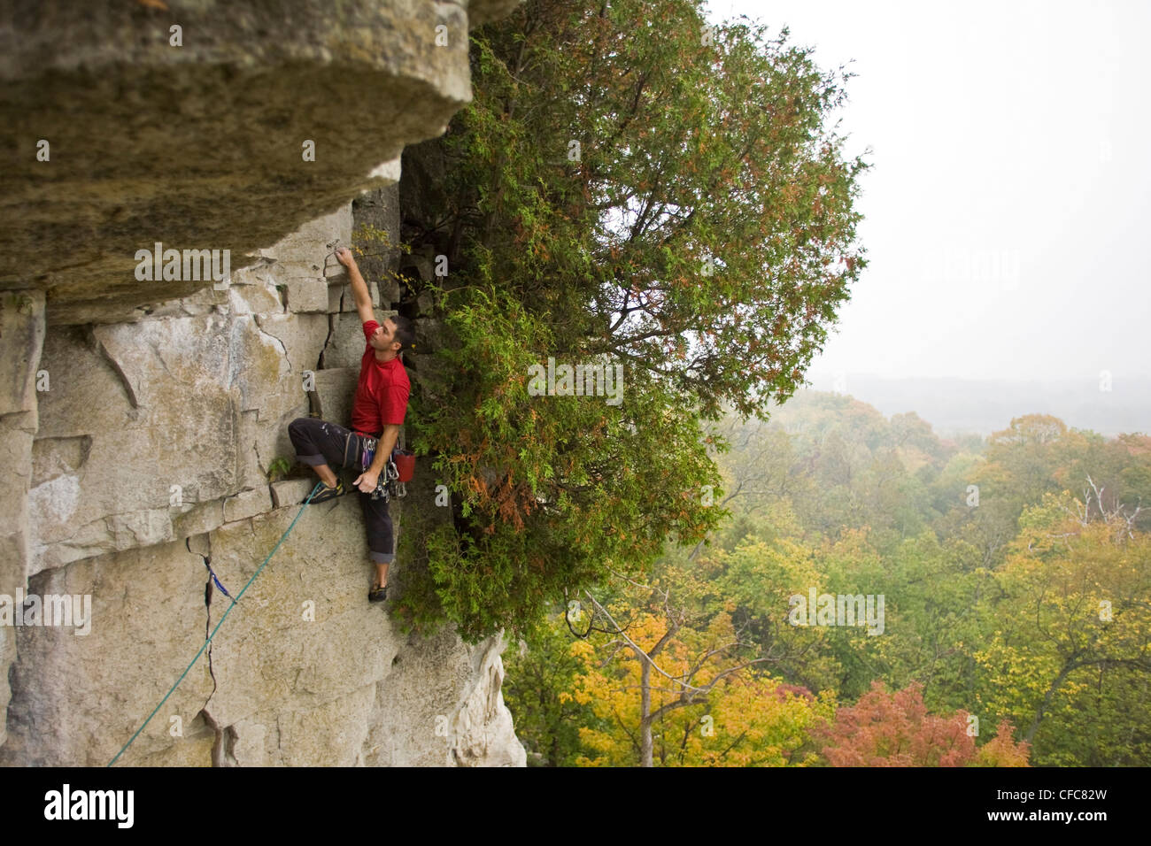 Un jeune homme grimpe le massepain, 5,8 point, sur Snake Rattle Banque D'Images